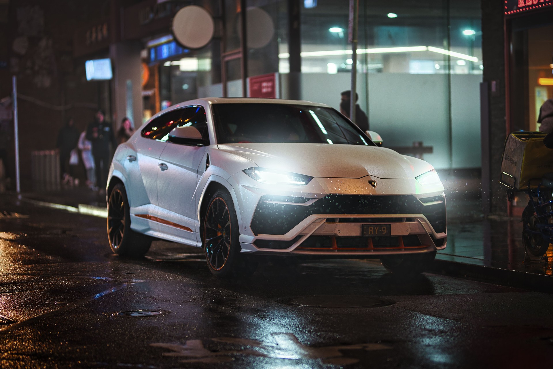 White Lamborghini Urus parked in the middle of Chinatown at night White Lamborghini Urus parked in the middle of Chinatown at night